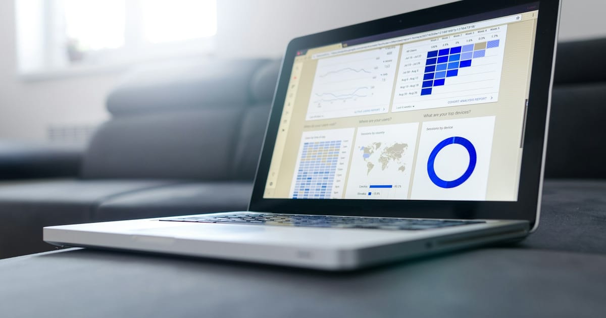 Open laptop showing a spreadsheet with charts on a sofa