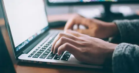 Person typing on a laptop at a desk
